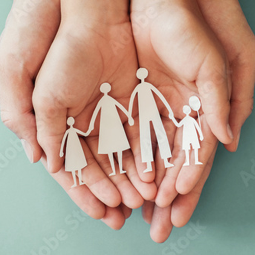 hands holding a paper cut out of a family